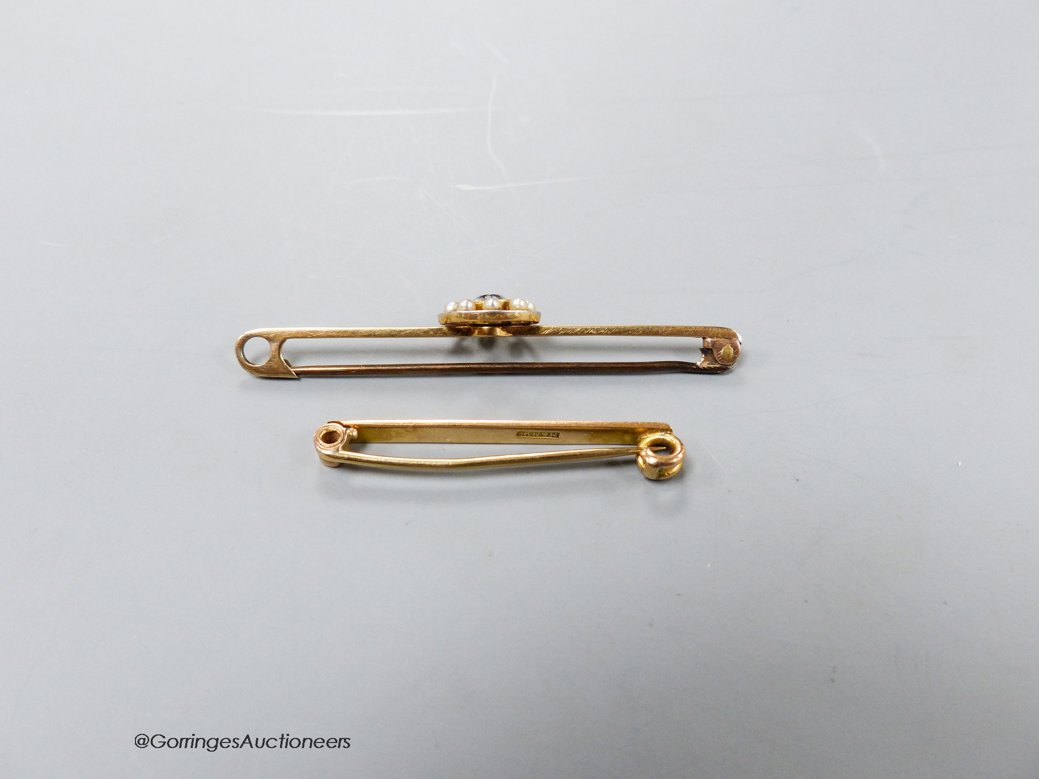 An Edwardian 15ct, aquamarine and seed pearl set bar brooch, 56mm, gross 3.5 grams and a 9ct bar brooch, 2 grams.
